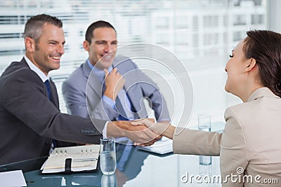 Cheerful young woman shaking hands with her future employer