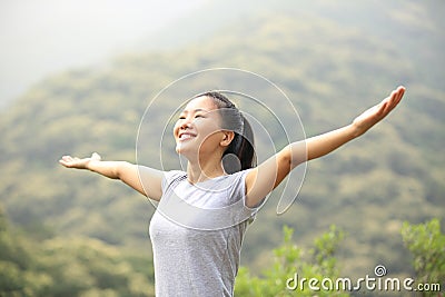 Cheering woman open arms mountain peak