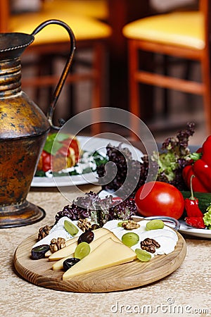 Cheese and fruits wooden platter with vegetables