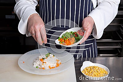 Chef add vegetables to risotto