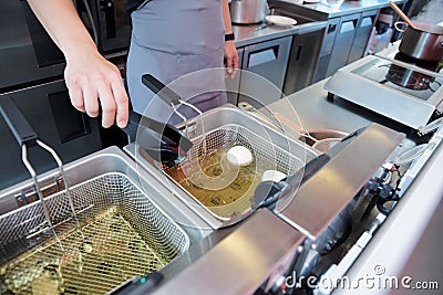 Chef cooking dish in a deep fryer