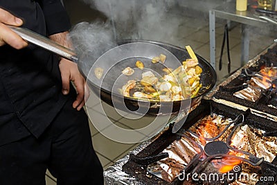 Chef is cooking seafood dish