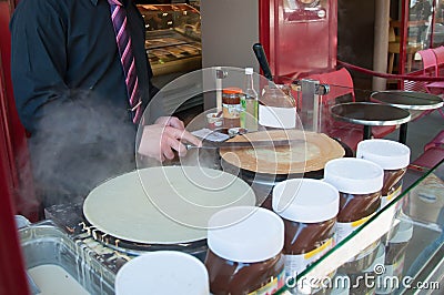 Chef preparing a crepe in front of the cafe in paris