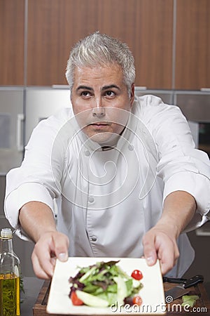 Chef Presenting Side Salad In Commercial Kitchen