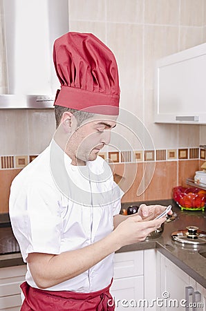 Chef touching smartphone in the kitchen