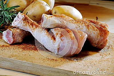 Chicken thighs and potatoes on a chopping board