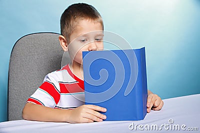 Child boy kid reading a book on blue