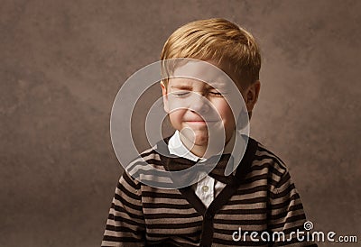 Child with closed eyes. Boy in brown retro bow tie