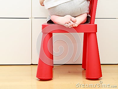 Child feet on baby chair, kids home safety concept