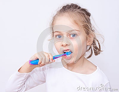 Child girl in pyjamas brushing teeth - bedtime hygiene