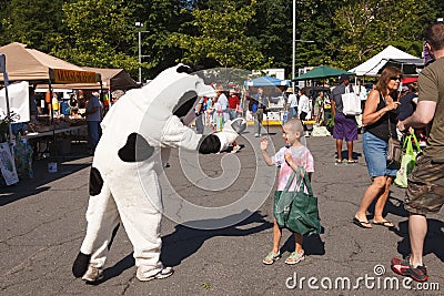 Child Greets Costumed Cow Character