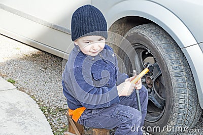 Child helps dismantle a car wheel