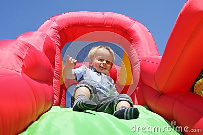 Child on inflatable bouncy castle slide