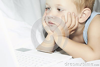 Child with laptop. 4 years old boy watching computer