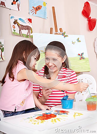 Child painting with mother at home.