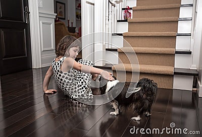 Child playing with a dog inside the house