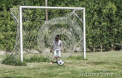 Child playing football in a stadium