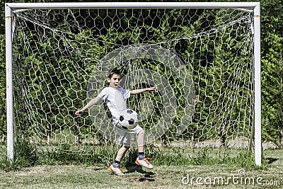 Child playing football in a stadium