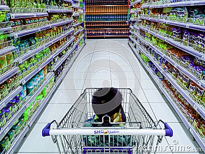 Child riding a grocery cart in a grocery