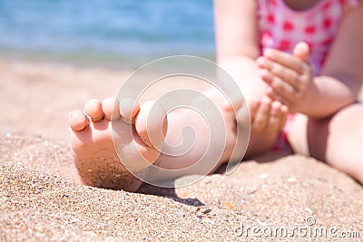Child s foot is close to the beach