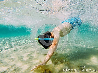 Child snorkeler reaching the bottom