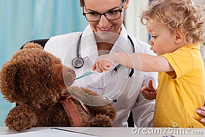 Child taking temperature of teddy bear