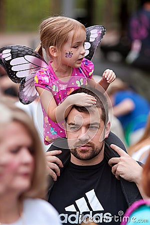 Child Wearing Wings Rides Father s Shoulders At Butterfly Festival