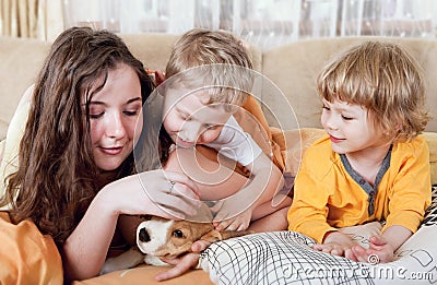 Children with beagle puppy in the bed