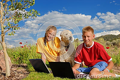 Children with dog and laptops