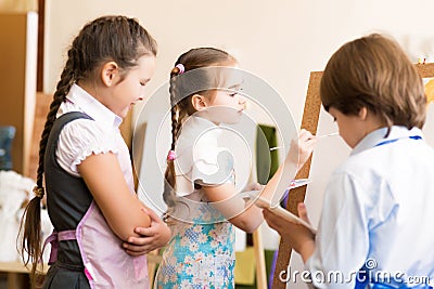 Children draw pictures of easels