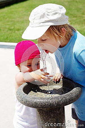 Children drinking water in a drinking fountain