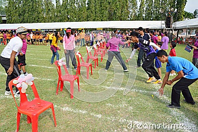 Children and parents doing a teamwork racing at Kindergarten sport day