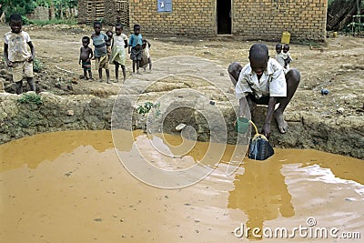 Children playing and boy fetch dirty water from well