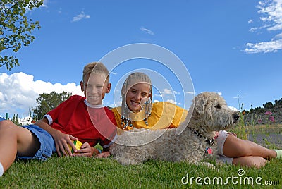 Children relaxing with dog