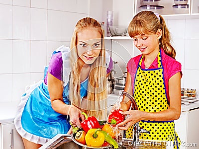 Children washing fruit at kitchen.