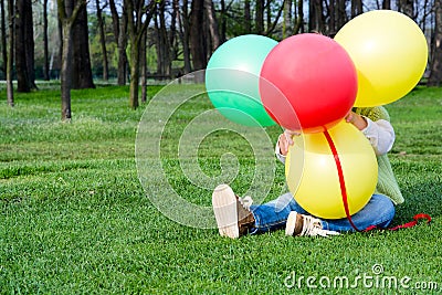 Chilld hiding behind balloons