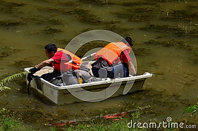 Chinese men in boat clean lake