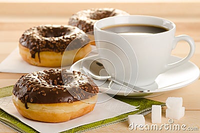 Chocolate donuts with coffee and sugar on the wooden table