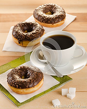 Chocolate donuts with coffee and sugar on the wooden table