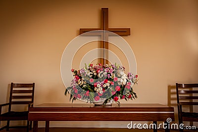 Christian cross and flowers on altar