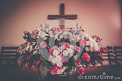 Christian cross and flowers on altar