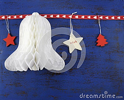 Christmas background with paper bell on dark blue vintage wood.