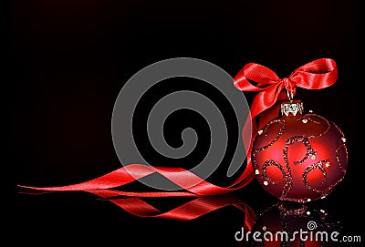 Christmas background with red ornament and ribbon on a black background