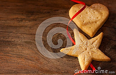 Christmas cookies and red ribbon on vintage wood background