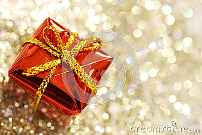 Christmas red gift box with yellow bow on glitter silver and gold background