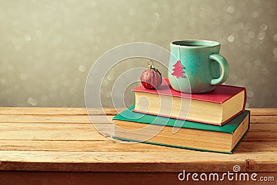 Christmas tea cup and ball on vintage books over blur background