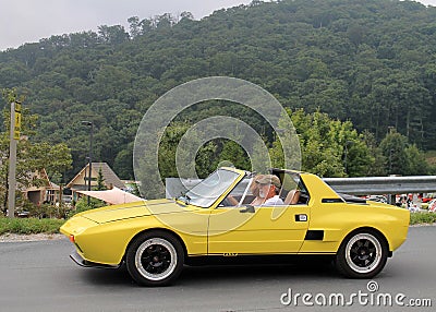 Classic yellow italian sports car on downhill road