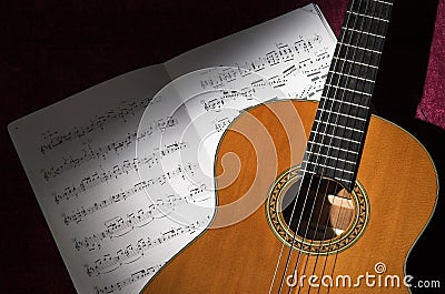 Classical guitar and sheet music in spot light