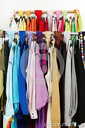 Close up on color coordinated clothes on hangers in a store.