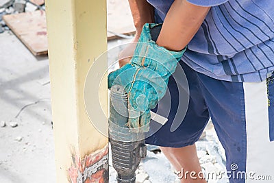 Close up detail of worker drilling holes in steel construction with electric drill